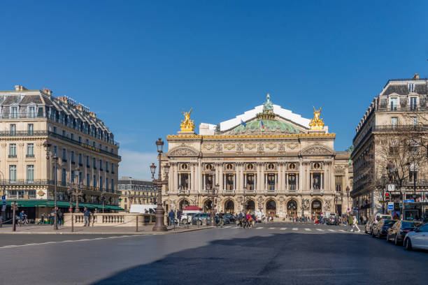 People walking in the Place de l´opera (Opera square) next to the Palais Garnier Opera House (Opera du Paris) at Paris city, France. People walking in the Place de l´opera (Opera square) next to the Palais Garnier Opera House (Opera du Paris) at Paris city, France. Inaugurated in 1875, it is one of the most famous places in Paris. place de lopera stock pictures, royalty-free photos & images