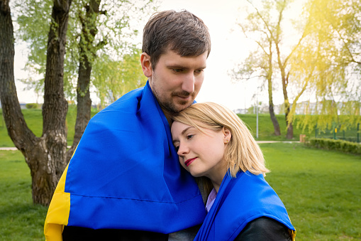 Happy people together with ukraine flag in the park. Free lifestyle.