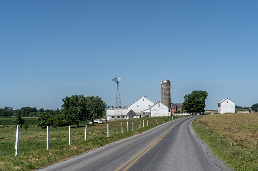 Amish Farm with white barn and windmill.