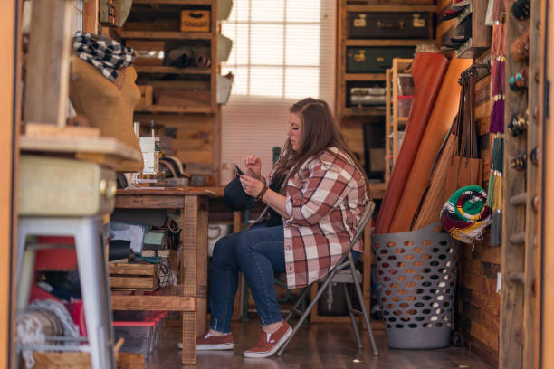 istock Female entrepreneur working with leather in workshop 1404283607