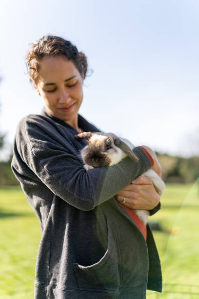 istock Beautiful woman snuggling pet rabbit outside 1404284474
