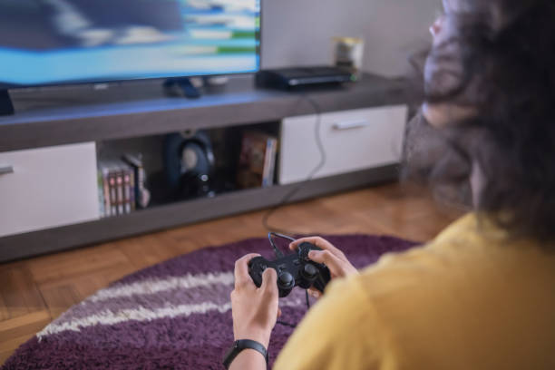 istock Focused man playing car racing video game 1404284523