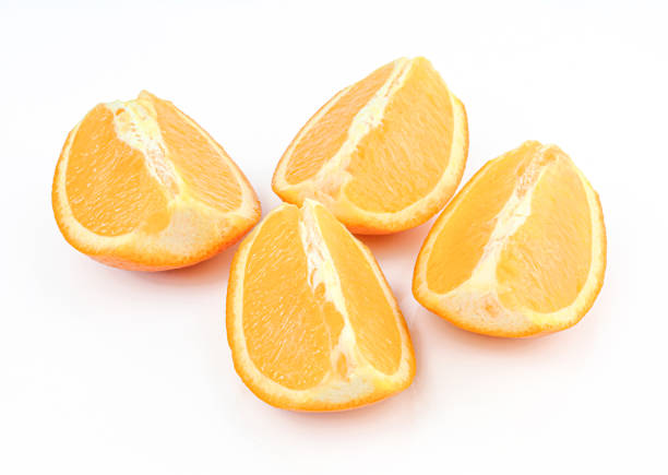 свежие дольки апельсина выделены на белом фоне. фруктовые четвертинки - quartered стоковые фото и изображения