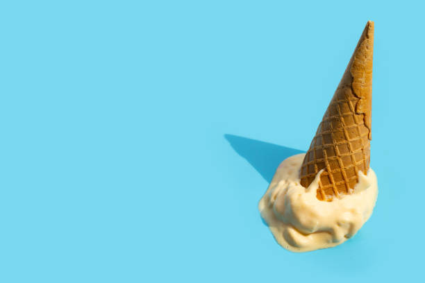 istock Melting ice cream balls with waffle cone on blue background. 1404288633