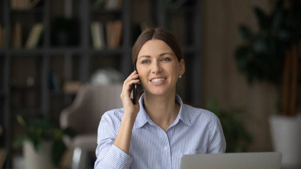 istock Attractive business lady sit at workplace desk talk on cellphone 1404288791