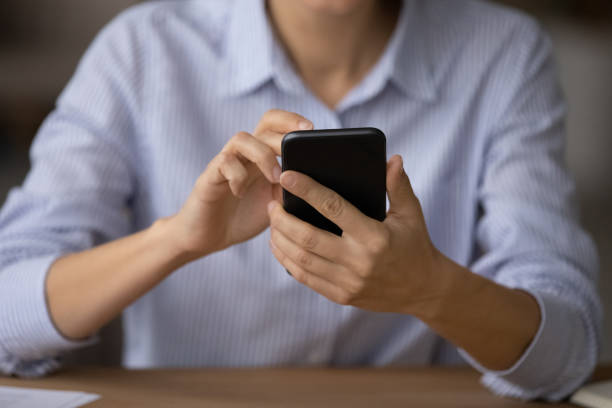 istock Close up female hands holding smartphone use new mobile app 1404288792