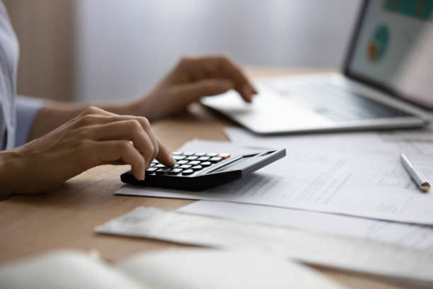 istock Close up view woman using laptop and calculator 1404288795