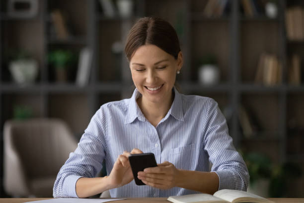 istock Attractive woman sit at desk using modern smartphone 1404288805