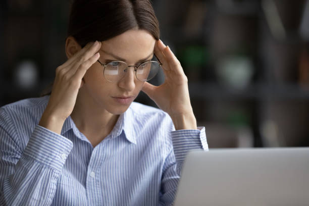 istock Serious businesswoman looks at laptop stuck with difficult task 1404288854