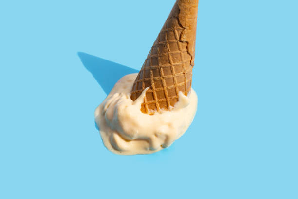istock Melting ice cream balls with waffle cone on blue background. 1404288870