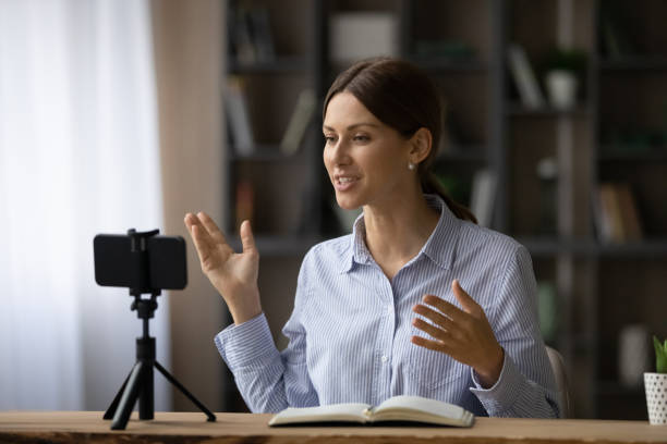 istock Attractive professional young woman record educational webinar on cellphone 1404289789