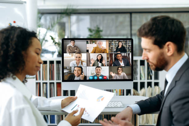 Company co-founders, a caucasian man and an african american woman, sit in a modern office in front of a computer screen, have an online video meeting with colleagues, demonstrate company profit charts los cofundadores de la compañía, un hombre caucásico y una mujer afroamericana, se sientan en una oficina moderna frente a la pantalla de una computadora, tienen una reunión de video en línea con colegas, demuestran los gráficos de ganancias de la co