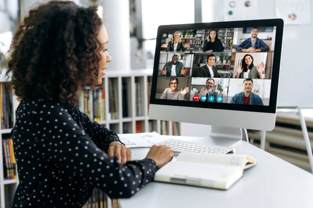 African american business woman, sits in front of a computer screen, talks via video link with international colleagues, employees, discusses a future project, perspective, business strategy, plan stock photo