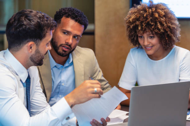istock Three business people meeting and looking at a laptop and a document. 1404294061