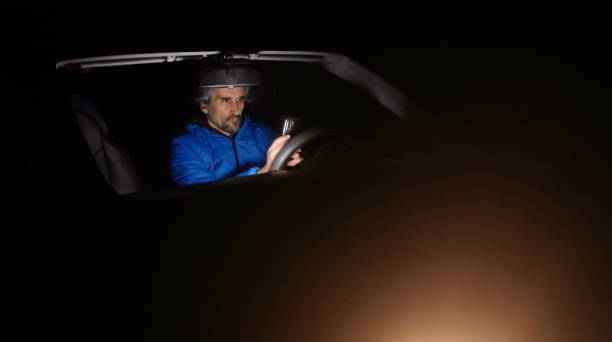 istock Man in car browsing  the social media on phone at night. 1404300513