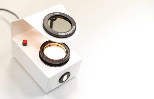 The Gemologist's expertise in her laboratory fixes the value of the precious stone of the polariscope.
