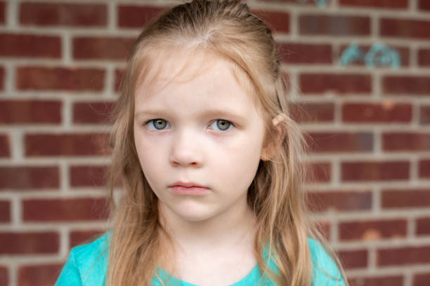 istock Pretty elementary age girl has a blank expression and is staring into the camera. 1404309430