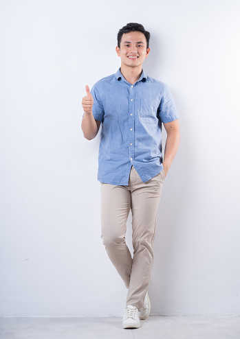 Full length image of young Asian man on white background