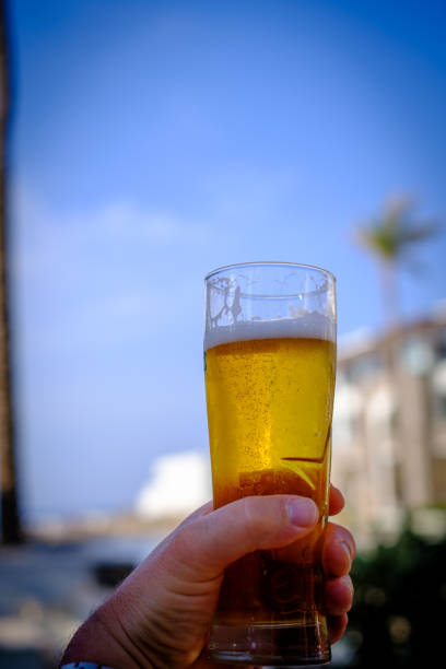 istock a hand holds a filled beer glass in the air 1404324724