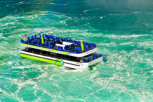 Niagara Falls, Ontario, Canada - June 17, 2022: The electric-powered “Maid of the Mist” tour boat approaches Horseshoe Falls on the Canadian side of world-famous Niagara Falls.