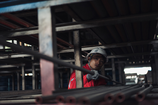 Metal industry - A worker moving ductile iron pipes in a warehouse