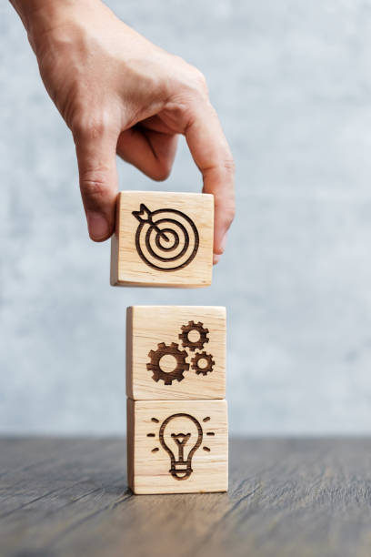 hand hold wood block with business goal, strategy, target, mission, action, objective, teamwork and idea concept