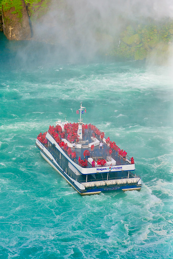 Niagara Falls, Ontario, Canada - June 17, 2022: The “Niagara Thunder” tour boat takes tourists to the foot of Horseshoe Falls at the world-famous Niagara Falls.