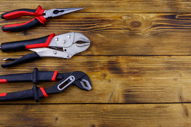 istock Set of different pliers on wooden background. Top view, copy space 1404330163