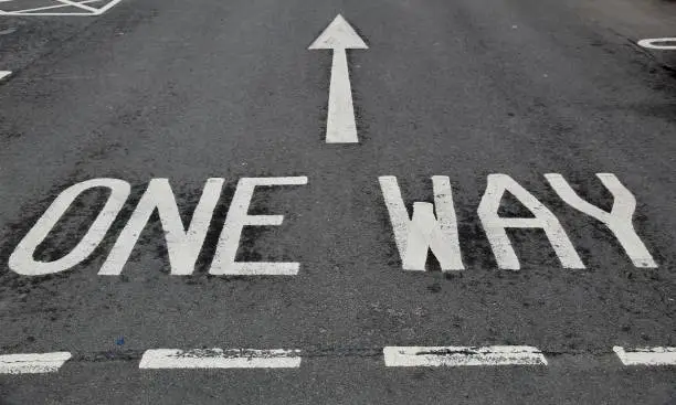 One way written with an arrow painted on the tarmac with white road paint at a car park near Edinburgh Scotland