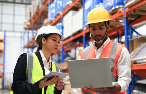 istock Warehouse or Supply chain engineer work with worker to check inventory at site line of High Rack Warehouse 1404333645