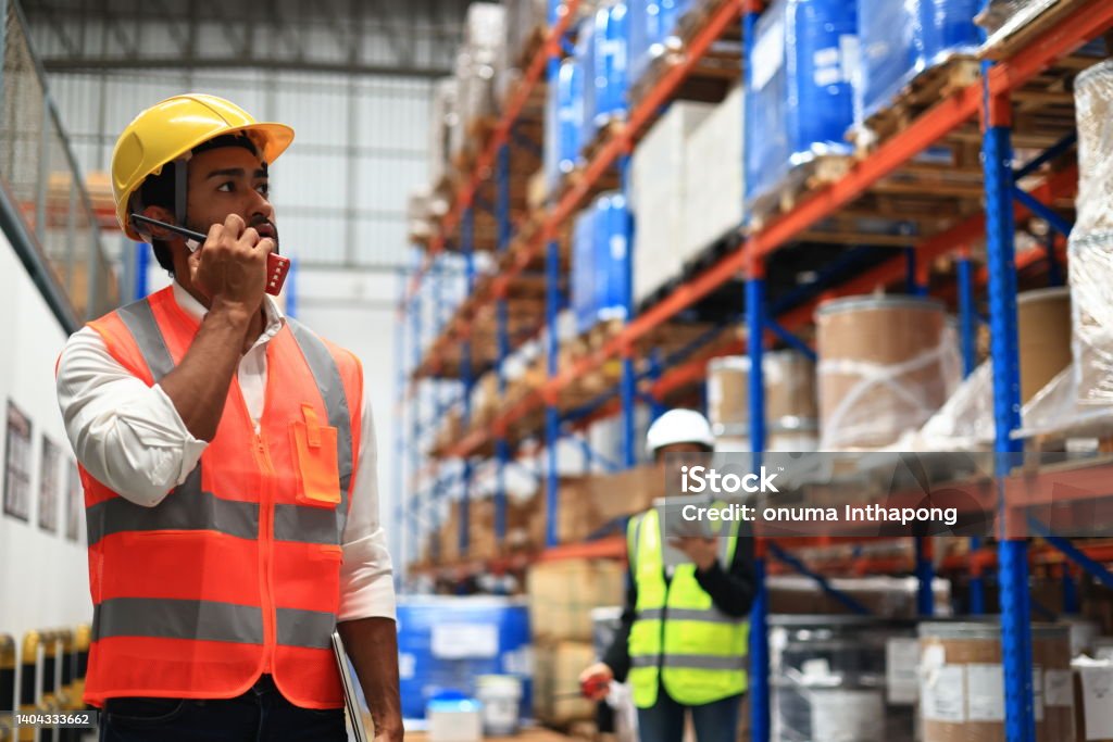 Warehouse or Supply chain engineer work with worker to check inventory at site line of High Rack Warehouse Responsibility Stock Photo