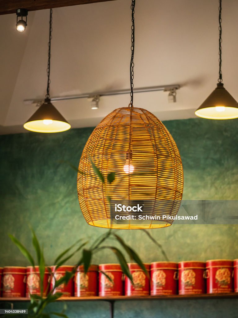 A rattan ceiling pendant lamp hangs in the center of the coolie pendant lamps. Home lighting and decoration. Home lighting and decoration. A rattan ceiling pendant lamp hangs in the center of the coolie pendant lamps. Beauty Stock Photo