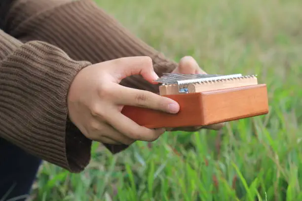 Photo Girl Hand Playing Kalimba, acoustic music instrument from africa