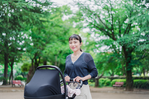 A mom pushing a stroller with a smile
