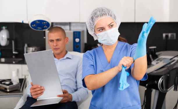 Woman doctor putting on gloves before consultation