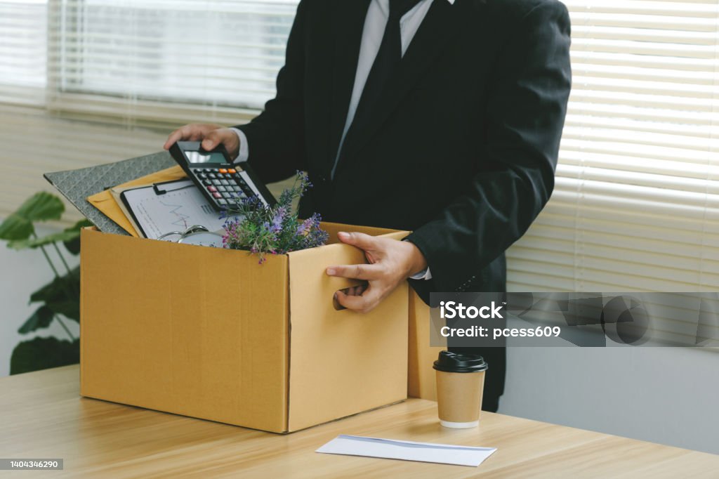 Resignation.Businessmen packing Stuff Resign Depress or carrying business cardboard box by the desk in the office. Quitting a job, The big quit. The great Resignation.Unemployment Quitting a Job Stock Photo