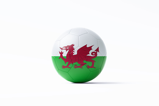 Soccer ball textured with Welsh flag sitting on white background. Horizontal composition with copy space. Clipping path is included.