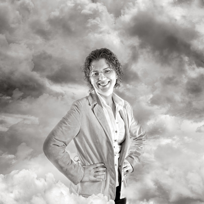 Portrait of curly white mid adult businesswoman over dramatic sky