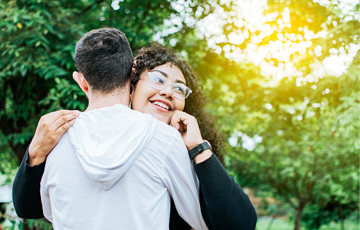 Teenage couple hugging outdoors, Close up of happy couple hugging in nature, Close up of smiling teenage couple hugging