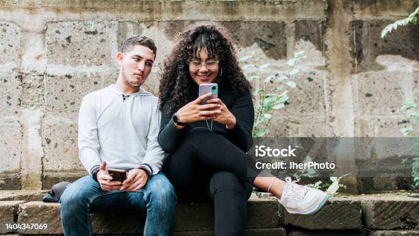 Suspicious Person Spying On His Girlfriend Phone Jealous Guy Spying On His Girlfriend Phone Distrustful Boyfriend Spying On His Girlfriend Phone Stock Photo - Download Image Now