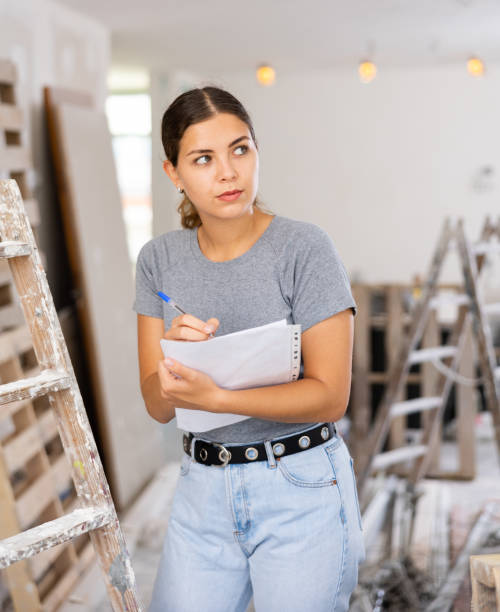 istock Female architect matching check list during repair works 1404352129