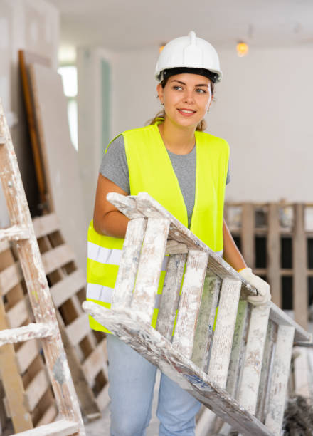 istock Young woman builder carrying stepladder 1404352227