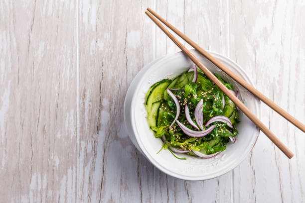 Traditional Japanese Sunomono salad with cucumber and wakame seaweed and sesame seeds Traditional Japanese Sunomono salad with cucumber and wakame seaweed and sesame seeds sunomono stock pictures, royalty-free photos & images