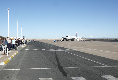 Passengers near a Eurowings Airline at Hosea Kutako International Airport of Windhoek in Khomas Region, Namibia. This is a German airline owned by Lufthansa.