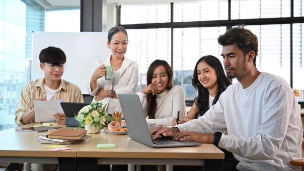 istock Smiling female manager and diverse young employees discussing project developing financial research, working together in office. 1404352711