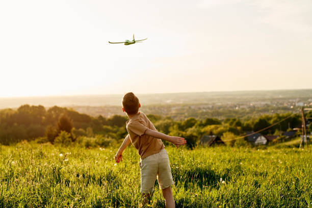 istock Little boy with toy airplane at meadow 1404352846