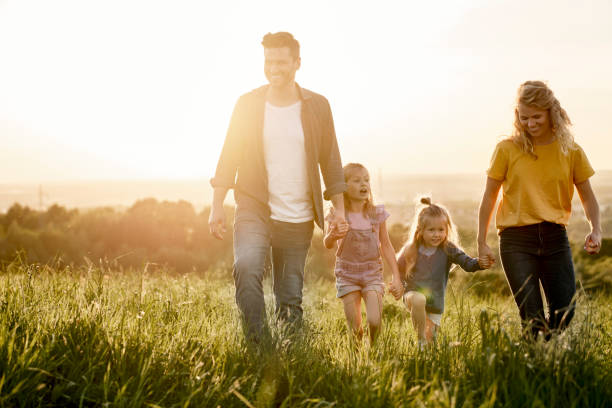 istock Happy family with two daughters walking at the meadow 1404353773