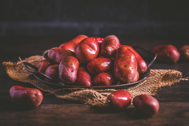 木製の背景に有機生の赤いジャガイモ - red potato raw potato burlap red ストックフォトと画像