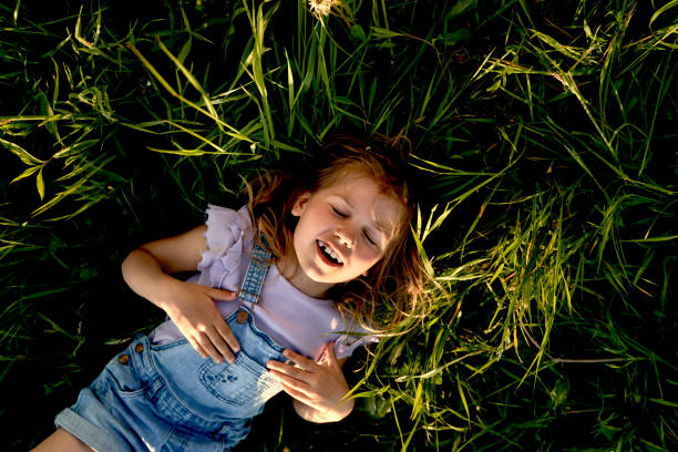 Caucasian little girl lying down on the grass