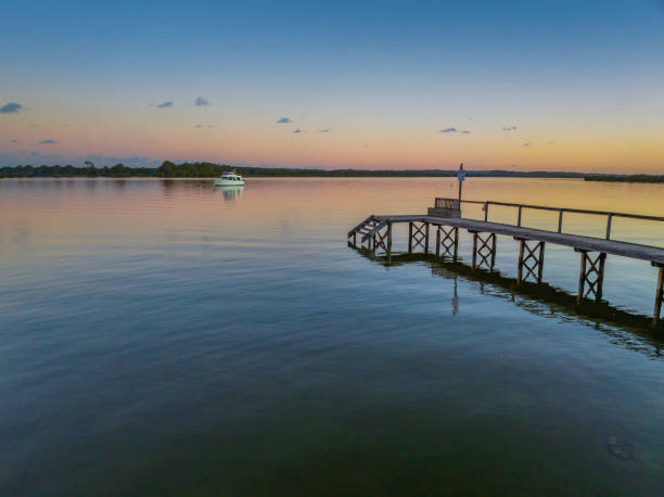 istock Sunset over the river with boat and wharf 1404355425